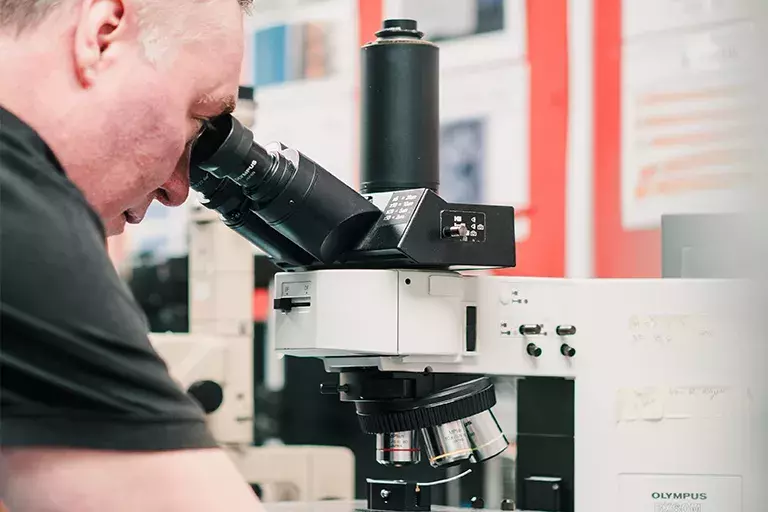 man looking into a microscope